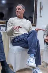 A speaker gesturing during an informal fireside session