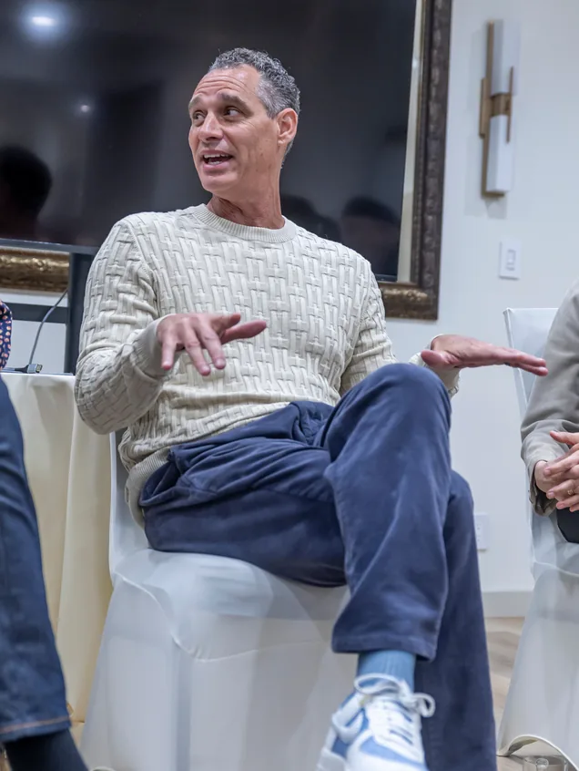 A speaker gesturing during an informal fireside session