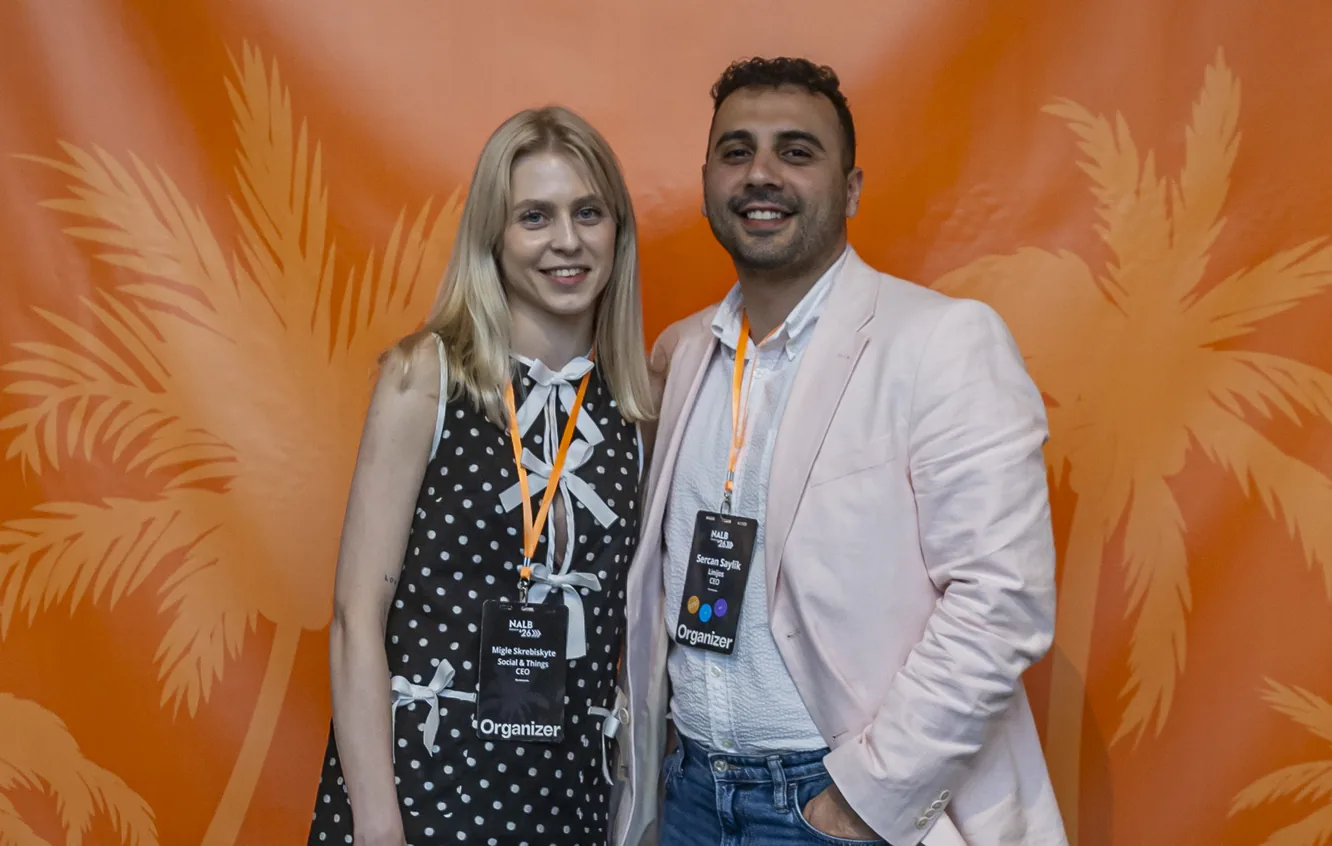 Two attendees posing together in front of a decorative backdrop