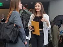 A participant laughing while talking with colleagues
