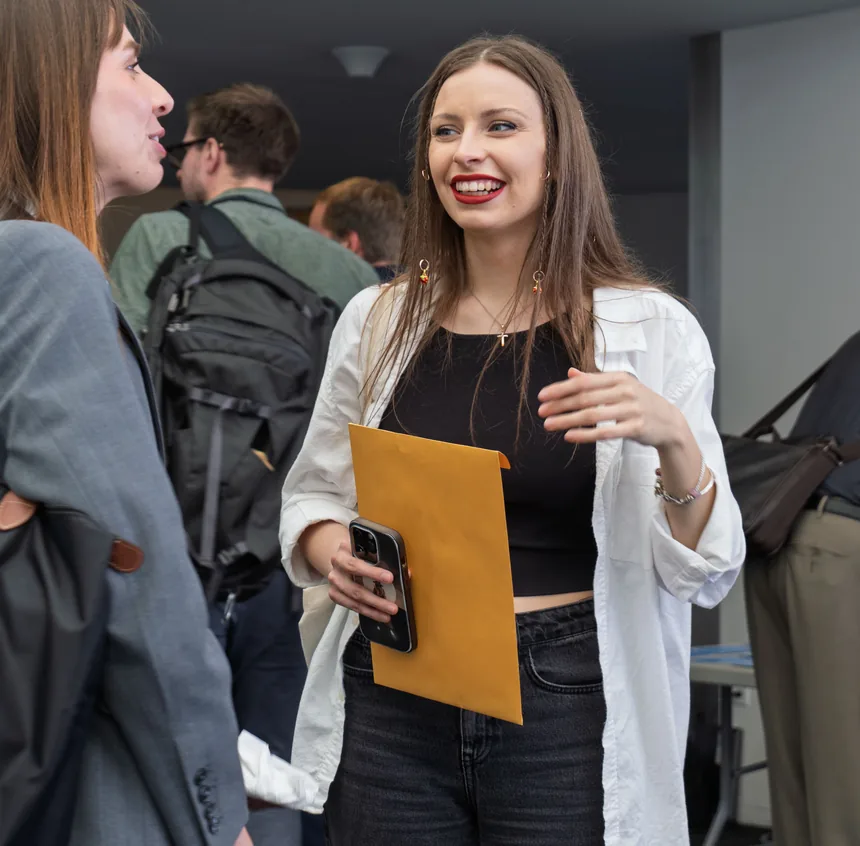 A participant laughing while talking with colleagues